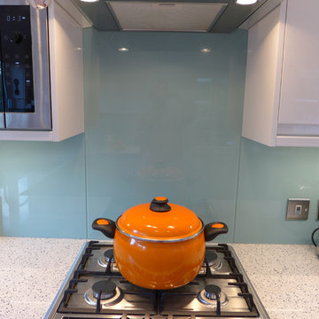modern white gloss kitchen with gas hob in quartz worktop