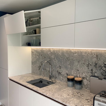 Modern white handleless kitchen with feature quartz