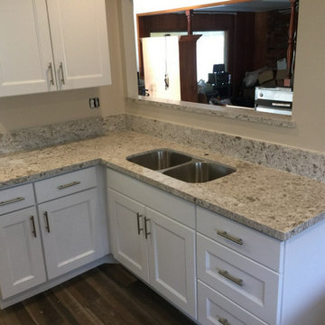 Modern white kitchen cabinets with chrome white quartz countertops