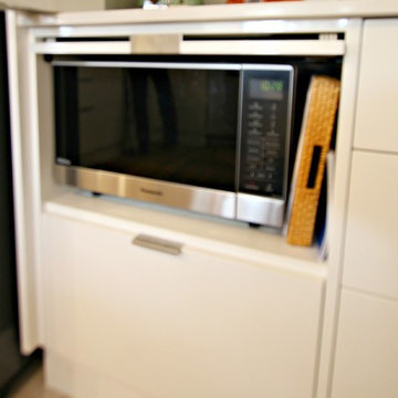 Modern White Kitchen - pocket door to hide microwave