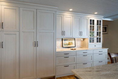 Kitchen pantry - large modern u-shaped light wood floor kitchen pantry idea in Bridgeport with an island, an undermount sink, raised-panel cabinets, white cabinets, granite countertops, multicolored backsplash, stone slab backsplash and stainless steel appliances