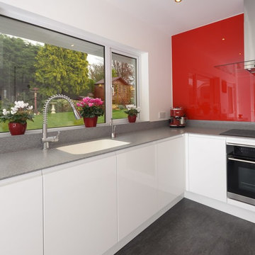 Modern white kitchen with accent red splashback