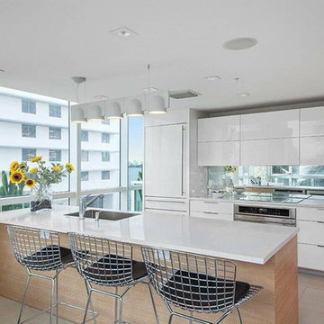 Modern white kitchen with engineered counters and glass mosaic accent column