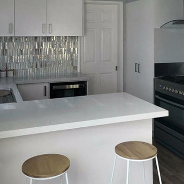 Modern white kitchen with silver metallic recycled glass backsplash