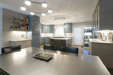 Modern inredning av ett mellanstort kök, med en undermonterad diskho, luckor med infälld panel, blå skåp, bänkskiva i kvarts, stänkskydd med metallisk yta, stänkskydd i metallkakel, vita vitvaror, ljust trägolv, en köksö och grått golv