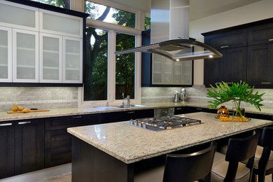 Eat-in kitchen - mid-sized transitional l-shaped travertine floor and beige floor eat-in kitchen idea in Other with an undermount sink, shaker cabinets, dark wood cabinets, granite countertops, gray backsplash, stone tile backsplash, stainless steel appliances and an island