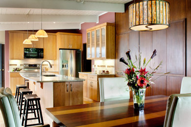 Example of a mid-sized mid-century modern l-shaped medium tone wood floor and brown floor eat-in kitchen design in Denver with an undermount sink, flat-panel cabinets, medium tone wood cabinets, granite countertops, beige backsplash, porcelain backsplash, stainless steel appliances and an island
