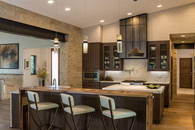 Example of a trendy l-shaped light wood floor open concept kitchen design in Albuquerque with quartz countertops, white backsplash, stone slab backsplash, stainless steel appliances, an island and white countertops