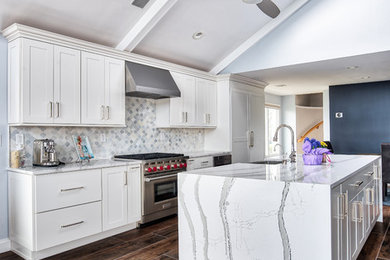 Example of a huge beach style kitchen design in New York with shaker cabinets, white cabinets, quartz countertops, white backsplash, two islands and white countertops