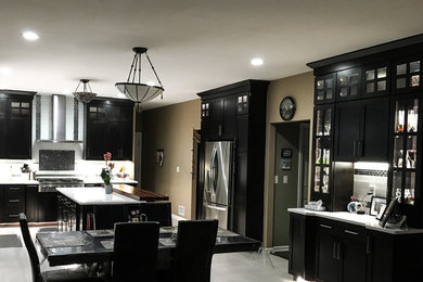 Example of a mid-sized trendy l-shaped porcelain tile and gray floor eat-in kitchen design in New York with an undermount sink, shaker cabinets, dark wood cabinets, quartz countertops, white backsplash, ceramic backsplash, stainless steel appliances and an island