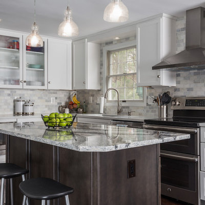 Example of a mid-sized transitional l-shaped dark wood floor and brown floor eat-in kitchen design in DC Metro with an undermount sink, shaker cabinets, white cabinets, quartz countertops, white backsplash, stone tile backsplash, stainless steel appliances and an island