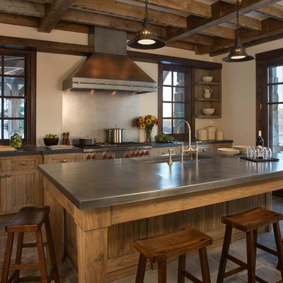 Example of a mid-sized mountain style galley slate floor and brown floor enclosed kitchen design in New York with an undermount sink, medium tone wood cabinets, stainless steel countertops, metallic backsplash, shaker cabinets, stainless steel appliances and an island