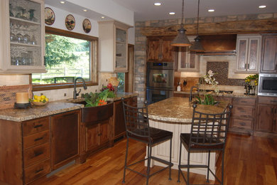 Inredning av ett klassiskt stort kök, med en undermonterad diskho, luckor med upphöjd panel, skåp i mellenmörkt trä, granitbänkskiva, beige stänkskydd, rostfria vitvaror, mellanmörkt trägolv och en köksö
