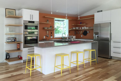 На фото: угловая кухня-гостиная среднего размера в морском стиле с плоскими фасадами, белыми фасадами и островом с