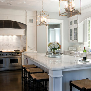 Неиссякаемый источник вдохновения для домашнего уюта: большая п-образная кухня в классическом стиле с обеденным столом, стеклянными фасадами, белыми фасадами, мраморной столешницей, белым фартуком, техникой из нержавеющей стали, темным паркетным полом, островом, фартуком из каменной плитки и врезной раковиной