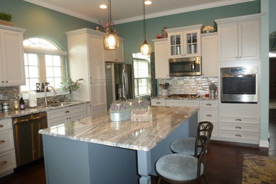 Inspiration for a mid-sized transitional u-shaped dark wood floor and brown floor eat-in kitchen remodel in Philadelphia with an undermount sink, raised-panel cabinets, distressed cabinets, granite countertops, gray backsplash, mosaic tile backsplash, stainless steel appliances, an island and gray countertops
