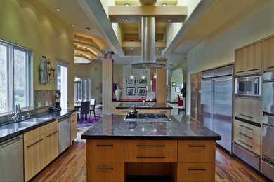 Photo of a large contemporary u-shaped kitchen/diner in San Diego with a submerged sink, flat-panel cabinets, light wood cabinets, granite worktops, metallic splashback, metal splashback, stainless steel appliances, medium hardwood flooring and multiple islands.