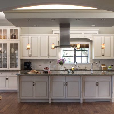 Inspiration for a timeless kitchen remodel in Los Angeles with glass-front cabinets, stainless steel appliances, white cabinets, white backsplash and granite countertops
