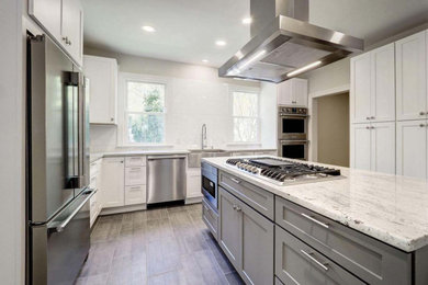 Eat-in kitchen - contemporary porcelain tile and gray floor eat-in kitchen idea in DC Metro with a farmhouse sink, shaker cabinets, white cabinets, white backsplash, subway tile backsplash, stainless steel appliances, an island and white countertops