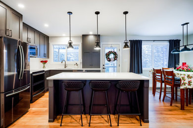 Small transitional l-shaped vinyl floor and brown floor eat-in kitchen photo in Other with an undermount sink, shaker cabinets, gray cabinets, quartz countertops, white backsplash, subway tile backsplash, stainless steel appliances, an island and white countertops