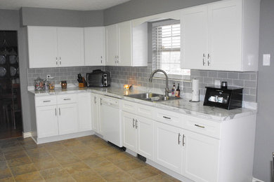 Exempel på ett mellanstort kök, med en nedsänkt diskho, skåp i shakerstil, vita skåp, laminatbänkskiva, grått stänkskydd, stänkskydd i keramik och vita vitvaror