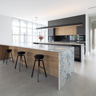Contemporary galley kitchen in Other with flat-panel cabinets, black cabinets, black appliances, multiple islands, grey floor and grey benchtop.
