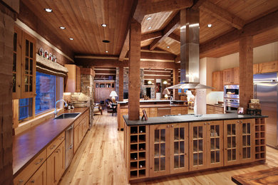 Huge mountain style u-shaped light wood floor eat-in kitchen photo in Other with a drop-in sink, glass-front cabinets, light wood cabinets, concrete countertops, brown backsplash, cement tile backsplash, stainless steel appliances and two islands