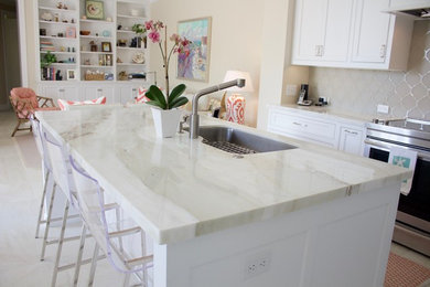 Kitchen - mid-sized coastal l-shaped porcelain tile and white floor kitchen idea in Miami with an undermount sink, shaker cabinets, white cabinets, marble countertops, gray backsplash, glass tile backsplash, stainless steel appliances and an island