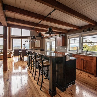 Large mountain style l-shaped light wood floor eat-in kitchen photo in Portland Maine with an undermount sink, flat-panel cabinets, medium tone wood cabinets, granite countertops, stainless steel appliances and an island