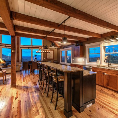 Eat-in kitchen - large rustic l-shaped light wood floor and brown floor eat-in kitchen idea in Portland Maine with an undermount sink, flat-panel cabinets, medium tone wood cabinets, granite countertops, stainless steel appliances and an island