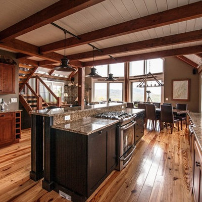 Example of a large mountain style l-shaped light wood floor eat-in kitchen design in Portland Maine with an undermount sink, flat-panel cabinets, medium tone wood cabinets, granite countertops, stainless steel appliances and an island