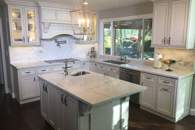 Mid-sized elegant l-shaped dark wood floor kitchen photo in San Francisco with an undermount sink, shaker cabinets, white cabinets, marble countertops, gray backsplash, stone tile backsplash and an island