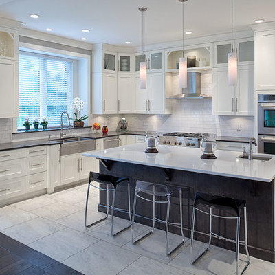 Example of a large transitional l-shaped ceramic tile eat-in kitchen design in Vancouver with a double-bowl sink, shaker cabinets, white cabinets, solid surface countertops, white backsplash, ceramic backsplash, stainless steel appliances and an island