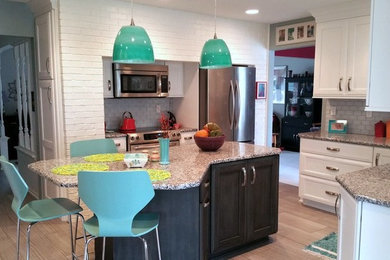 Transitional kitchen photo in Other with flat-panel cabinets, white cabinets, granite countertops, multicolored backsplash, glass tile backsplash, stainless steel appliances and an island