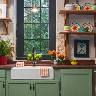 Design ideas for a mid-sized eclectic single-wall separate kitchen in Richmond with a farmhouse sink, shaker cabinets, green cabinets, wood benchtops, beige splashback, brick floors and red floor.