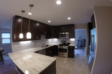 Inspiration for a mid-sized modern l-shaped porcelain tile kitchen remodel in Chicago with an undermount sink, dark wood cabinets, granite countertops, white backsplash, glass tile backsplash, stainless steel appliances and a peninsula