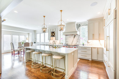 Inspiration for a large transitional l-shaped medium tone wood floor eat-in kitchen remodel in Birmingham with recessed-panel cabinets, gray cabinets, marble countertops, marble backsplash, paneled appliances and an island