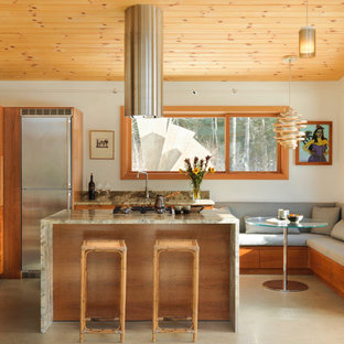 Inspiration för små rustika kök, med skåp i shakerstil, skåp i mellenmörkt trä, rostfria vitvaror, en köksö, en undermonterad diskho, granitbänkskiva, beiget golv och betonggolv