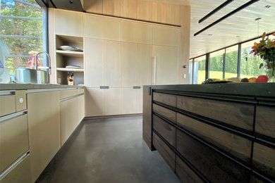 Example of a large trendy u-shaped concrete floor, gray floor and wood ceiling open concept kitchen design in Other with an undermount sink, flat-panel cabinets, light wood cabinets, yellow backsplash, glass sheet backsplash, paneled appliances, an island and gray countertops