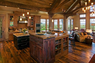 Open concept kitchen - rustic open concept kitchen idea in Denver with a farmhouse sink, glass-front cabinets, medium tone wood cabinets, wood countertops, brown backsplash and stainless steel appliances