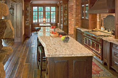 Inspiration for a large rustic single-wall dark wood floor eat-in kitchen remodel in Other with a farmhouse sink, recessed-panel cabinets, dark wood cabinets, granite countertops, colored appliances and an island