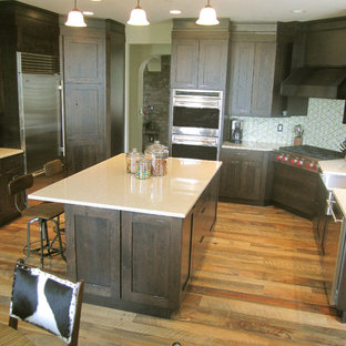 Large transitional open concept kitchen pictures - Open concept kitchen - large transitional u-shaped medium tone wood floor open concept kitchen idea in Denver with a farmhouse sink, shaker cabinets, dark wood cabinets, quartz countertops, green backsplash, glass tile backsplash, stainless steel appliances and an island