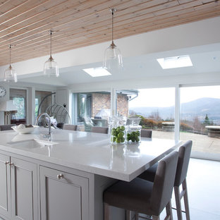 Ejemplo de cocina en U, de estilo de casa de campo, grande, abierta, con armarios estilo shaker, puertas de armario grises, encimera de mármol y península