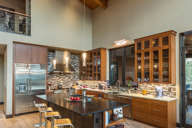 Foto på ett stort funkis kök, med en rustik diskho, öppna hyllor, skåp i mellenmörkt trä, granitbänkskiva, brunt stänkskydd, stänkskydd i glaskakel, rostfria vitvaror, ljust trägolv och en köksö