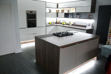 This is an example of a contemporary kitchen in West Midlands with integrated appliances and an island.
