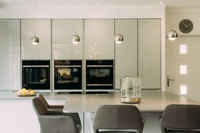 Large contemporary open plan kitchen in Cheshire with black appliances and an island.