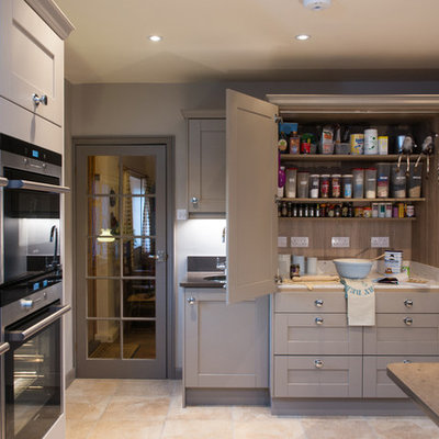 Example of a transitional kitchen design in Surrey with shaker cabinets, gray cabinets, stainless steel appliances and an island