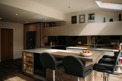 This is an example of a modern kitchen/diner in Cheshire with mirror splashback and an island.