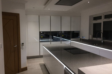 Inspiration for a large modern l-shaped open plan kitchen in Glasgow with a single-bowl sink, flat-panel cabinets, white cabinets, quartz worktops, multi-coloured splashback, stainless steel appliances, ceramic flooring, an island, multi-coloured floors and multicoloured worktops.