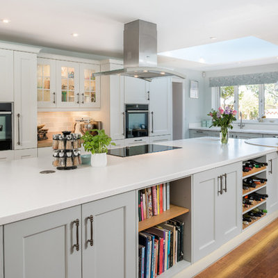 Kitchen - transitional medium tone wood floor kitchen idea in Other with shaker cabinets, gray cabinets, multicolored backsplash, subway tile backsplash, black appliances and an island